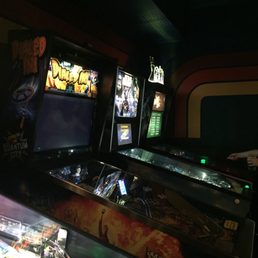a row of pinball machines in a game room a row of pinball machines in a game room