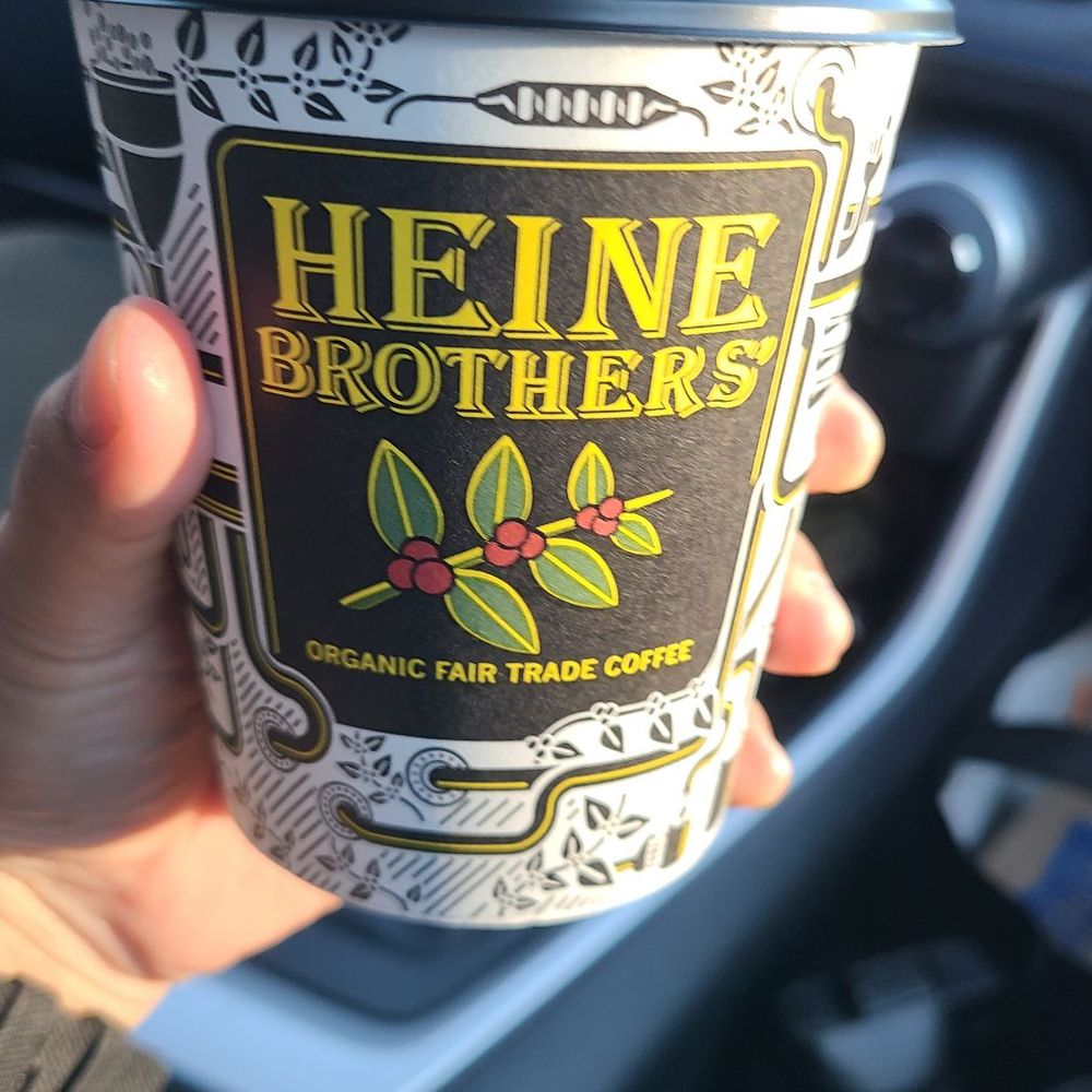Heine Brothers Coffee - a hand holding a coffee cup - Coffee & Tea Near Me - New Albany, Indiana Heine Brothers Coffee - a hand holding a coffee cup - Coffee & Tea Near Me - New Albany, Indiana