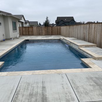 BluRock Pool Company - Swimming pool with raised wall, water feature, and travertine coping - Pool & Hot Tub Service Near Me BluRock Pool Company - Swimming pool with raised wall, water feature, and travertine coping - Pool & Hot Tub Service Near Me