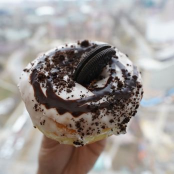 Dipped - a hand holding a chocolate covered doughnut - Donuts Near Me - Toronto, Ontario