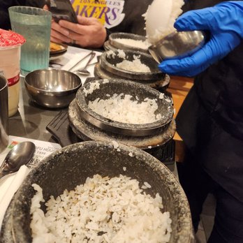 BCD Tofu House - Scooping fresh rice out of the stone pot bowls. - Korean Near Me - Irvine, California