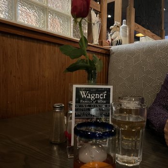 At Elm St Grill - a rose in a vase on a table - New American Near Me - Greensboro, North Carolina
