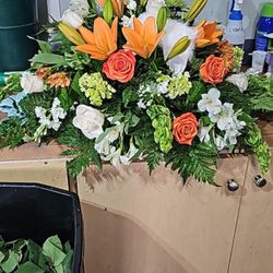 New Port Richey Florist - Orange green and white casket spray.
727 849 2222