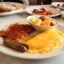 Village Inn - Cheese omelet with flat top hash browns, pork sausage, and a fruit cup.