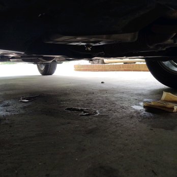 Grease Monkey - Oil in the center puddle from couple hours. Day before puddle with rags to the right. Left puddle is from AC condensation - Oil Change Stations Near Me - Holly Springs, North Carolina