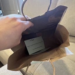 a person holding a brown paper bag a person holding a brown paper bag