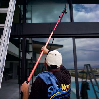 ShineNow Window Cleaning - ShineNow technician cleaning tall exterior windows on a modern Las Vegas home. - Window Washing Near Me ShineNow Window Cleaning - ShineNow technician cleaning tall exterior windows on a modern Las Vegas home. - Window Washing Near Me