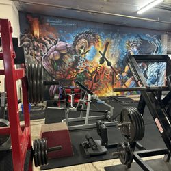 Iron Hawaiian Fitness - Leg area, with solid background design, clean weights and lots of machines.