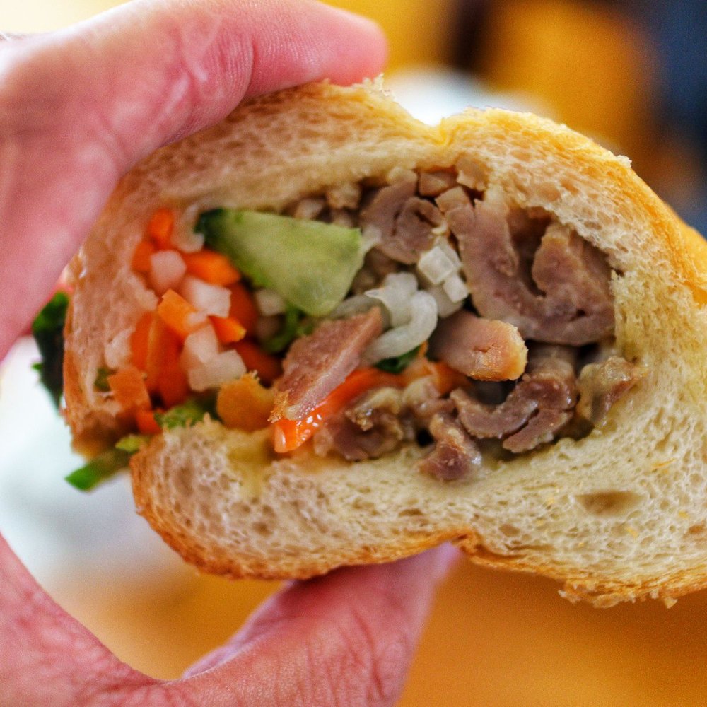 Pho Viet's - a hand holding a half eaten sandwich - Vietnamese Near Me - Boston, Massachusetts Pho Viet's - a hand holding a half eaten sandwich - Vietnamese Near Me - Boston, Massachusetts
