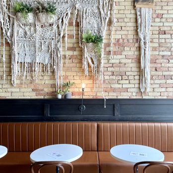 The Winchester - two tables and two chairs in front of a brick wall - Gastropubs Near Me - Grand Rapids, Michigan