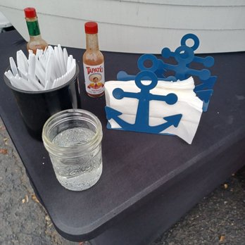 Hangar 76 - a table with a bottle of beer, napkins, and a bottle of ketchup - Wine Tasting Room Near Me - Oceanside, California