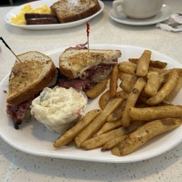Rachael sandwich with French fries. And potato salad Rachael sandwich with French fries. And potato salad