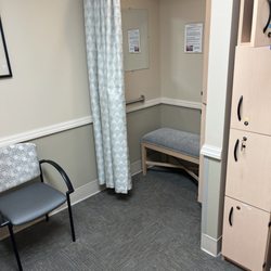 MercyOne Clive Imaging - Private changing room with sitting area, changing space with a bench and curtain, and lockers