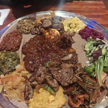 Chercher Ethiopian Restaurant & Mart - Veggie platter served on the outside. In the middle is Dora wat and beef tibs - Ethiopian Near Me - Washington, DC, District of Columbia