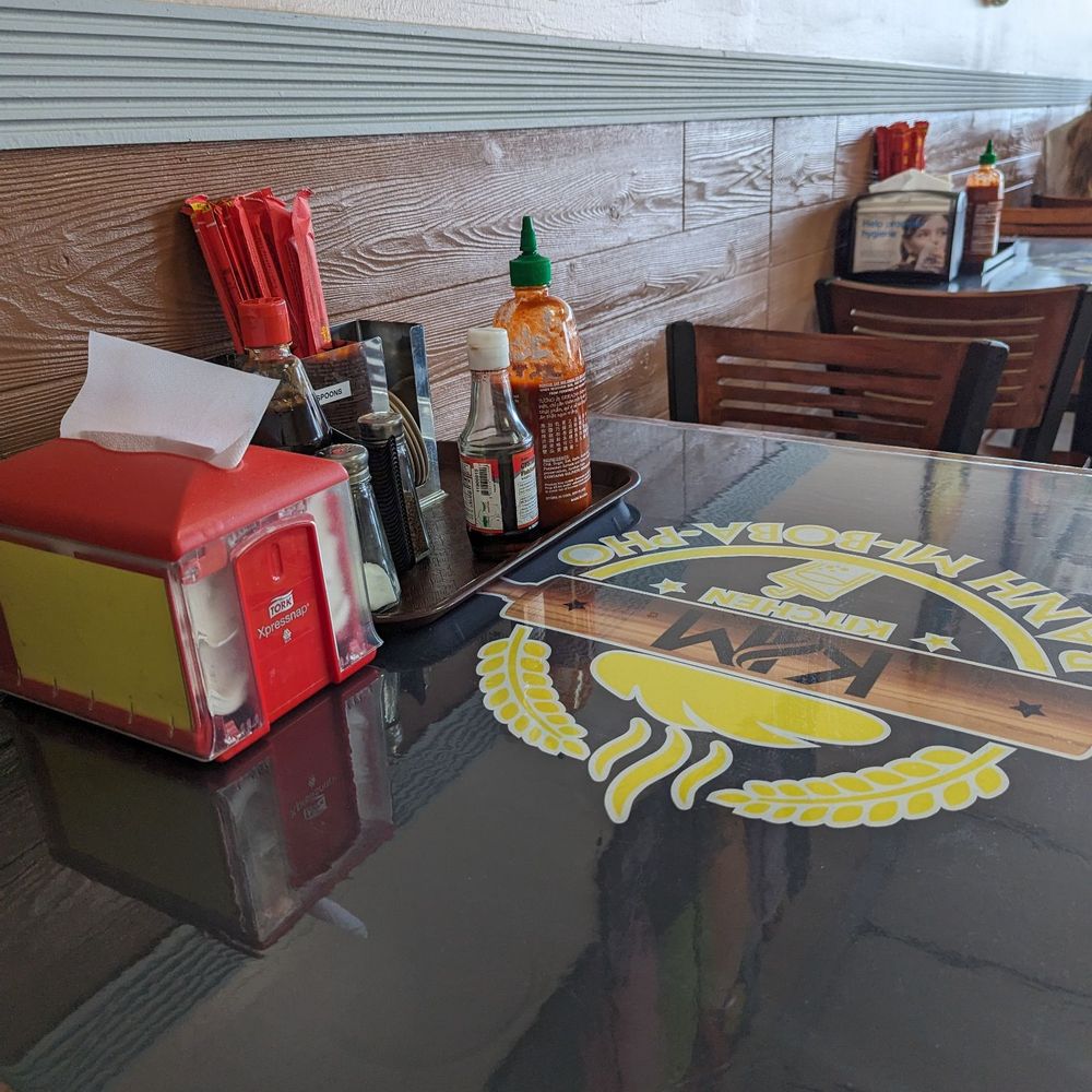 Kim Kitchen - Table set up with, fish sauce, Sriracha, hoisin, ect. - Vietnamese Near Me - Chattanooga, Tennessee