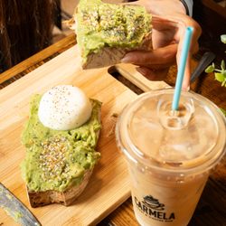 Fresh avocado toast with a poached egg paired with an iced latte at Carmela Coffee BRiC, Boca Raton...