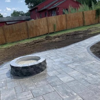 E & V Landscaping Construction - a patio with a fire pit - Landscaping Near Me