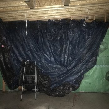 DICICCO BUILDERS - an unfinished basement with a tarp covering - General Contractors Near Me