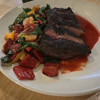 M’tucci’s Bar Roma - Hanger Steak Special ... super delicious! - A plate features a grilled hanger steak with a red sauce and a side of mixed vegetables, served in a restaurant setting. - Cocktail Bars Near Me - Albuquerque, New Mexico