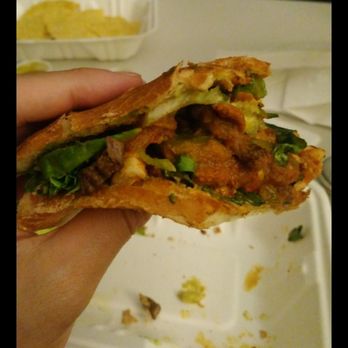 Tacos Sin Tequila - a hand holding a sandwich - Food Trucks Near Me - Queens, New York