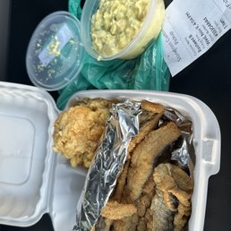 a container of fried fish and a container of macaroni and cheese a container of fried fish and a container of macaroni and cheese