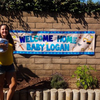 Apples & Oranges - "Welcome Home Baby Logan" banner with Mr. Baby Logan and proud Auntie. - Printing Services Near Me
