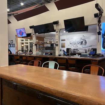 Dead Low Brewing - a bar with chairs and a television - Brewpubs Near Me - Cincinnati, Ohio
