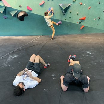 Bouldering Project - Springdale - Friends hanging out resting their arms - Gyms Near Me - Austin, Texas