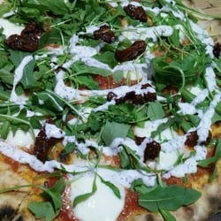 Pizza de tomate, búfala, trufa, rúcula y tomate seco