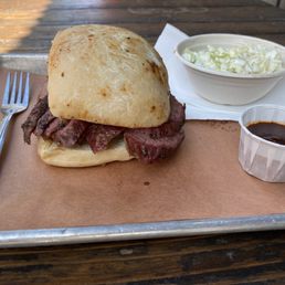 Tri-tip sandwich, barbecue sauce, and a side of coleslaw