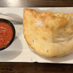Val's Italian Restaurant & Pizza - Spinach and cheese Calzone with side of marinara sauce