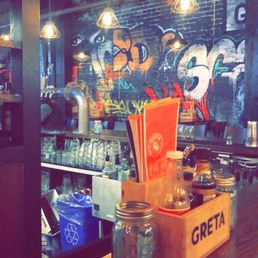 a wooden bar with graffiti on the wall