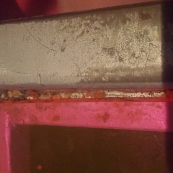 Big Pink - Dirrt that has fallen between the glass and table metal frame. The looks to have not been cleaned in quite some time. - Pizza Near Me - Miami Beach, Florida