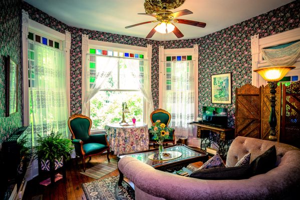 Bernhardt Suite | Premier King - Romantic King Jacuzzi suite, in a lovely Victorian home, with bay window view of downtown, full size living room, back deck, and a covered front porch over downtown.

In the 1892 Victorian building that was the home of Eureka Springs first Mayor
Best view from the large bay windows in your full sized living room, with original wood floors and stained glass
Very romantic pink and floral Victorian style
Covered front porch overlooking downtown
Back deck nestled into 25 foot limestone cliff
Two-person Jacuzzi and shower
First floor
King bed