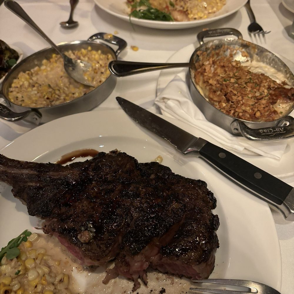 The Capital Grille - Porcini-Rubbed Bone-In Ribeye and Seared Sea Scallops with Maine Lobster and Asparagus Risotto. Creamed corn and au gratin potatoes. - Steakhouses Near Me - Minneapolis, Minnesota