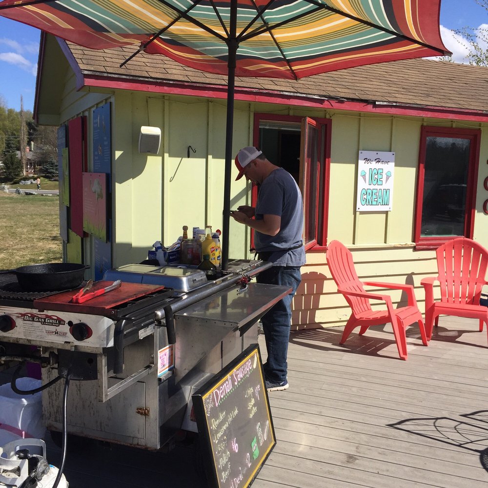 Denali Sausage - a man preparing food on a grill - Food Stands Near Me - Anchorage, Alaska Denali Sausage - a man preparing food on a grill - Food Stands Near Me - Anchorage, Alaska