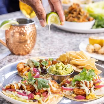 Moxies Kamloops Restaurant - a person sprinkling a lime over a plate of food - American Near Me - Kamloops, British Columbia