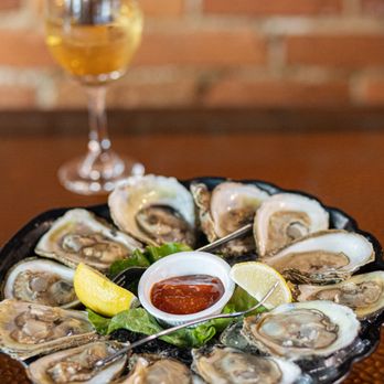 The Fin and Flame - a plate of oysters and a glass of wine - American Near Me - Palm City, Florida The Fin and Flame - a plate of oysters and a glass of wine - American Near Me - Palm City, Florida