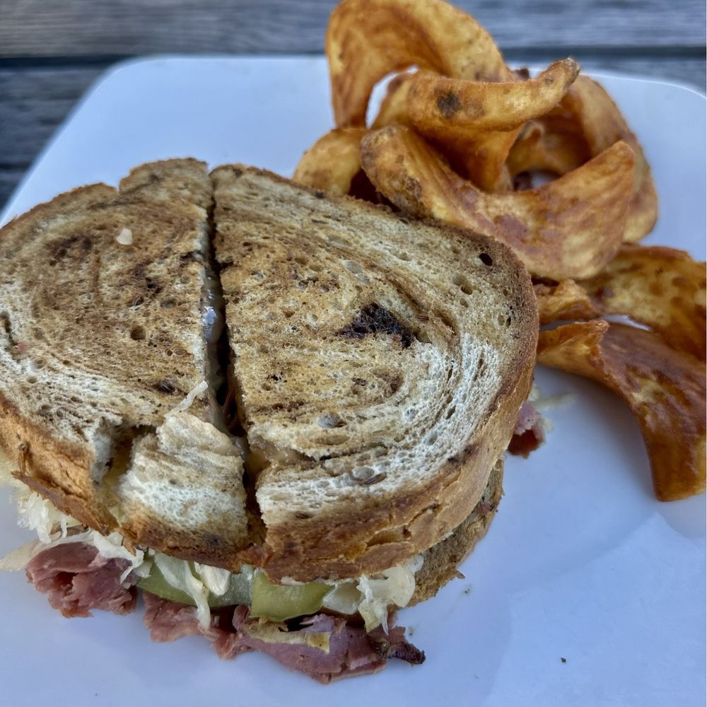 Off The Rails - Corned beef Rueben with sidewinder potatoes. - Irish Pub Near Me - Havana, Florida Off The Rails - Corned beef Rueben with sidewinder potatoes. - Irish Pub Near Me - Havana, Florida