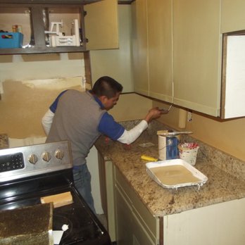 Precision Painting Company - a man painting a kitchen counter - Plumbing Near Me - Memphis, Tennessee Precision Painting Company - a man painting a kitchen counter - Plumbing Near Me - Memphis, Tennessee