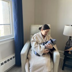The Village Postnatal Retreat Center - New Mom snuggling with her baby