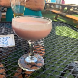 a pink drink in a glass on a table