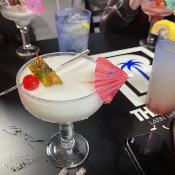The Blue Palm - a woman holding a cocktail - Latin American Near Me - Cleveland, Ohio The Blue Palm - a woman holding a cocktail - Latin American Near Me - Cleveland, Ohio