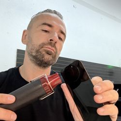iPhone Repair Xpress - the technician replaced the screen on iphone and is heating the front canera sensor to remove it, and install the new screen with sensor