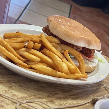 Roadside Restaurant - BLT - A burger with a bun, lettuce, tomato, and meat patty is served with French fries on a white oval plate. - New American Near Me - Bloomfield, New Mexico