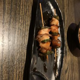 skewered shrimp on a black plate
