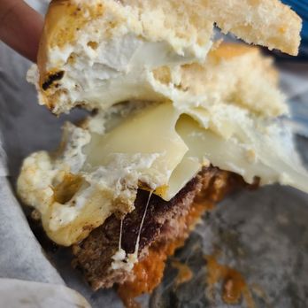 Lawrenceburger - a hand holding a half eaten sandwich - American Near Me - Lawrenceburg, Indiana