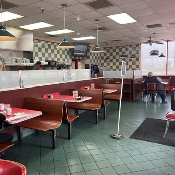 Huddle House - a woman sitting at a table in a diner - American Near Me - Madisonville, Kentucky