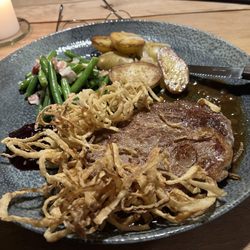 Gasthaus RamsAu - Steak with fresh green beans, new potatoes, and crispy tempura-fried onion rings. Steak is Fleckvieh (Simmental). 8 ounce cut.
