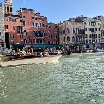 Canal Grande - A boat speeds along Canal Grande under Ponte di Rialto - Landmarks & Historical Buildings Near Me
